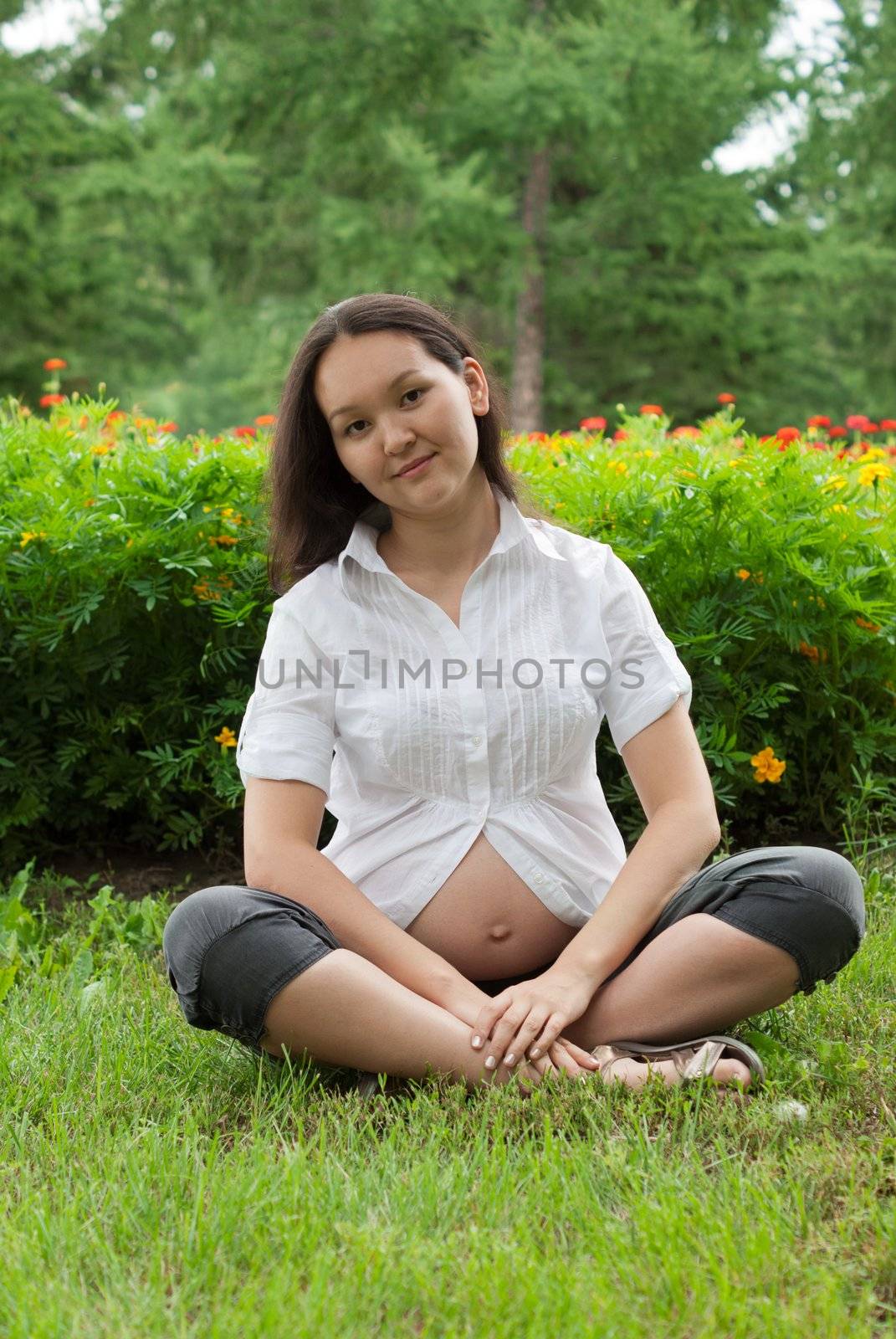 Young asian pregnant woman relaxing in the park