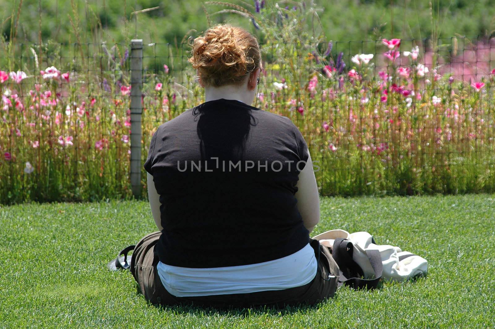 Overweight female sitting on the grass.