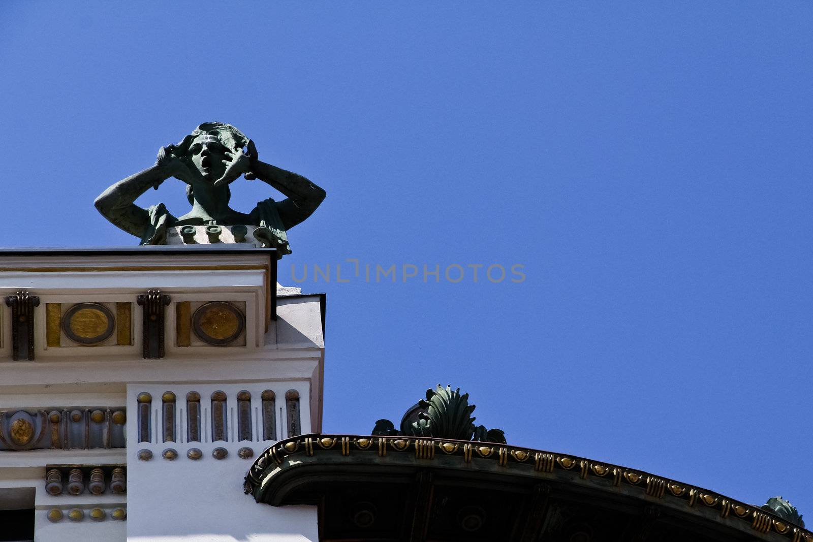 A sculpture of a screaming woman on top of an art building in Vienna, Austria