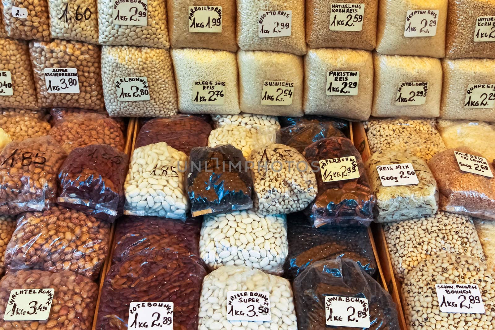 Bags full of different kinds of wheat, nuts and beans on a market stand