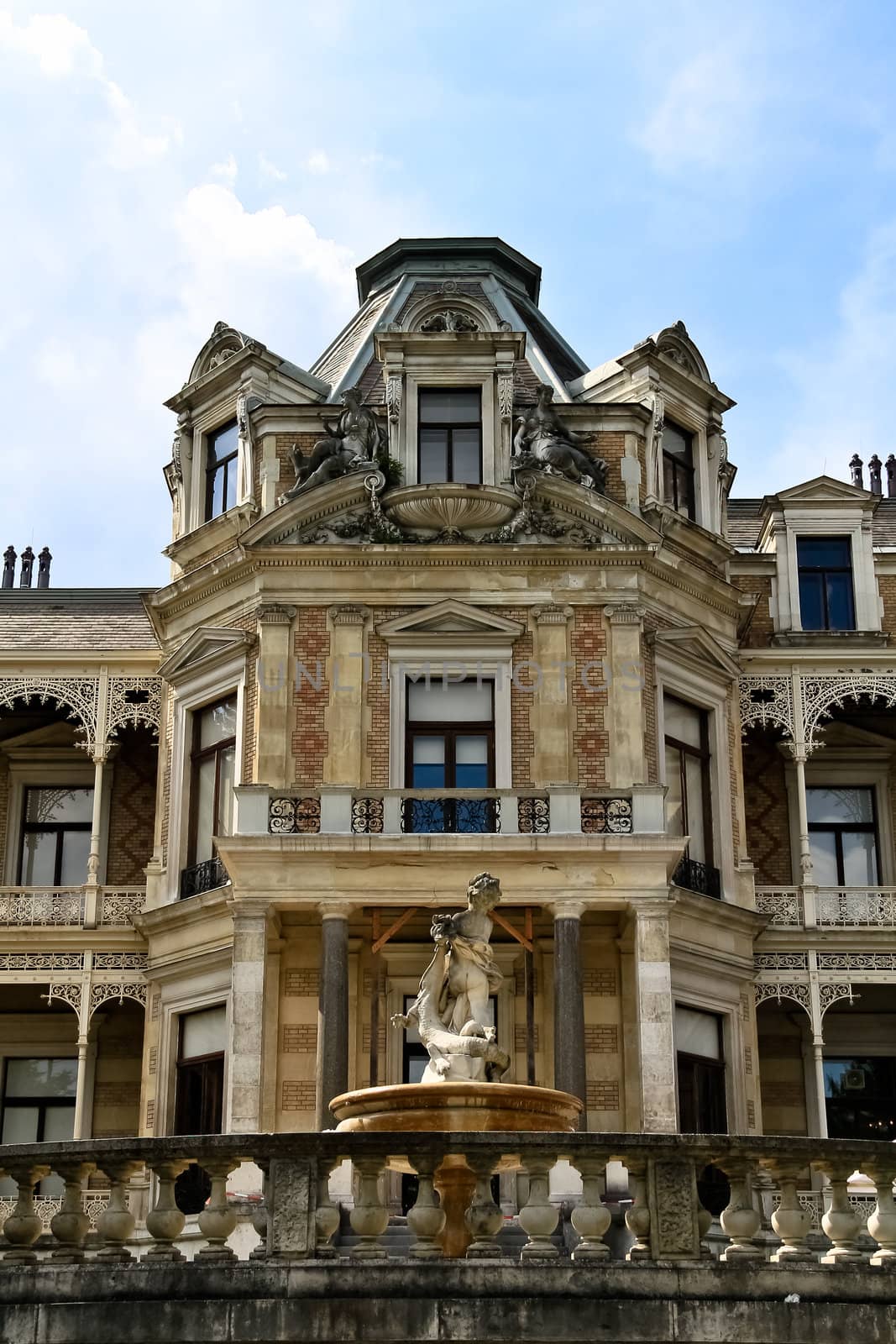 Facade of an old villa in Austria with a fountain in front