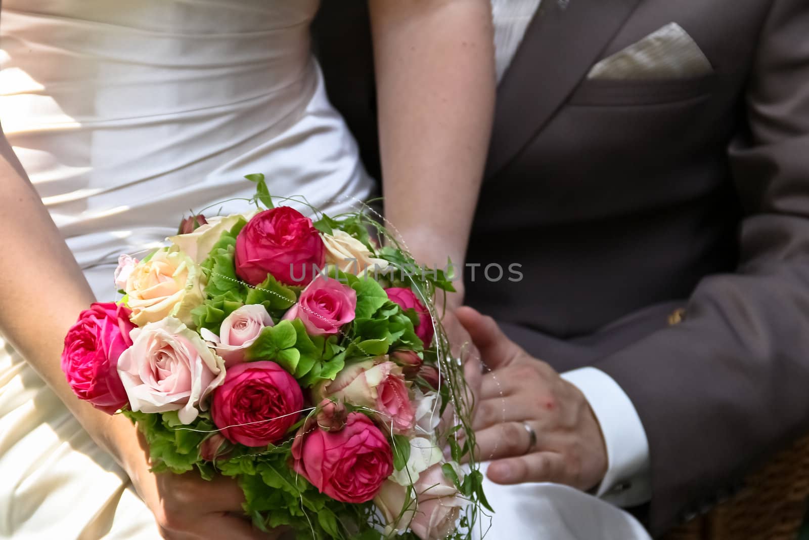 A newly wed couple showing off the bride's bouquet