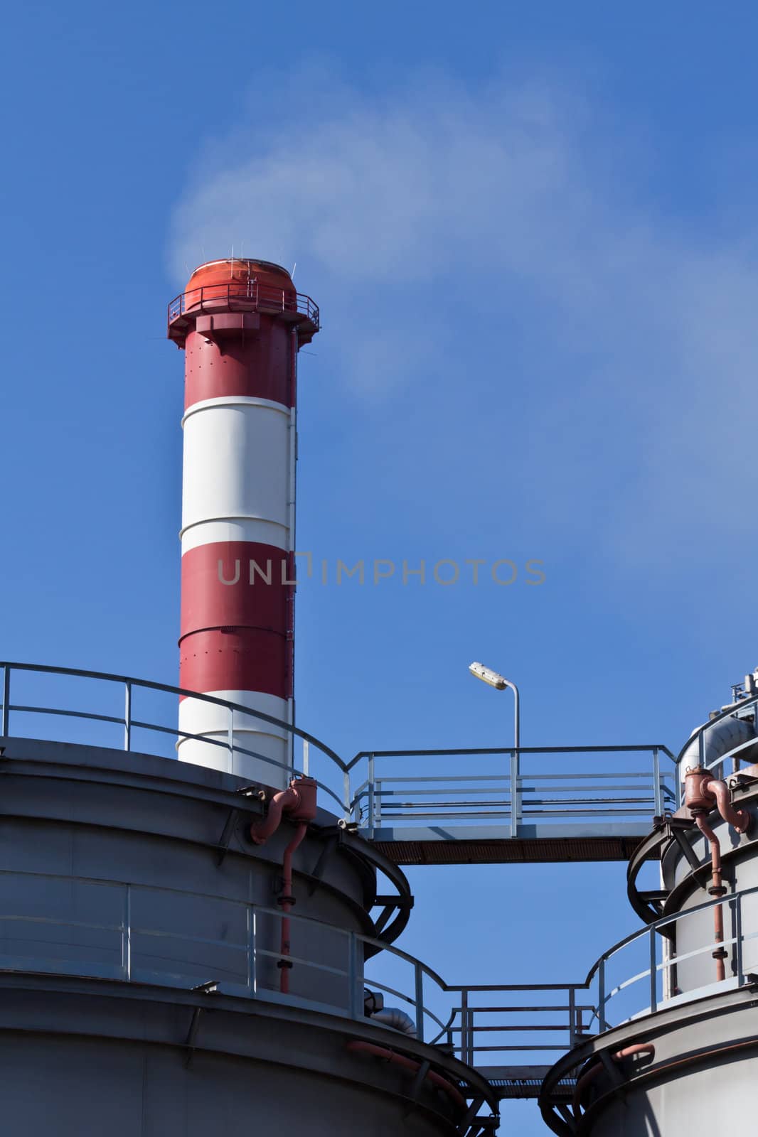 An industrial building with a chimney and smoke