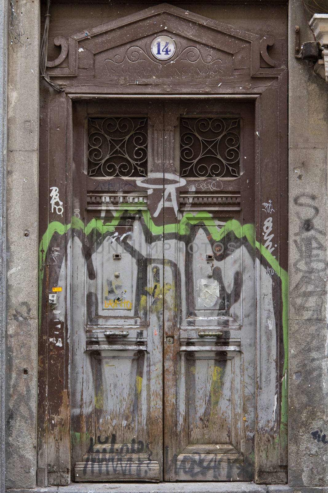 A dirty door with ugly graffiti in Madrid, Spain