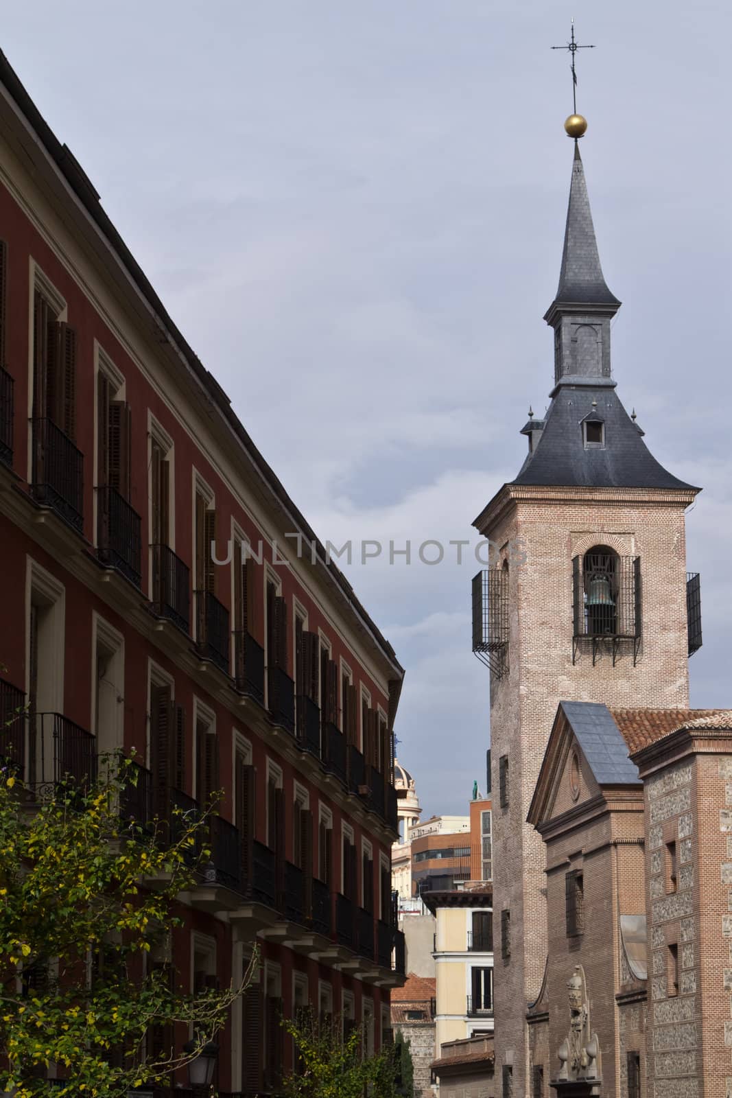 A spanish street in the center of Madrid with a church opposite a classical building