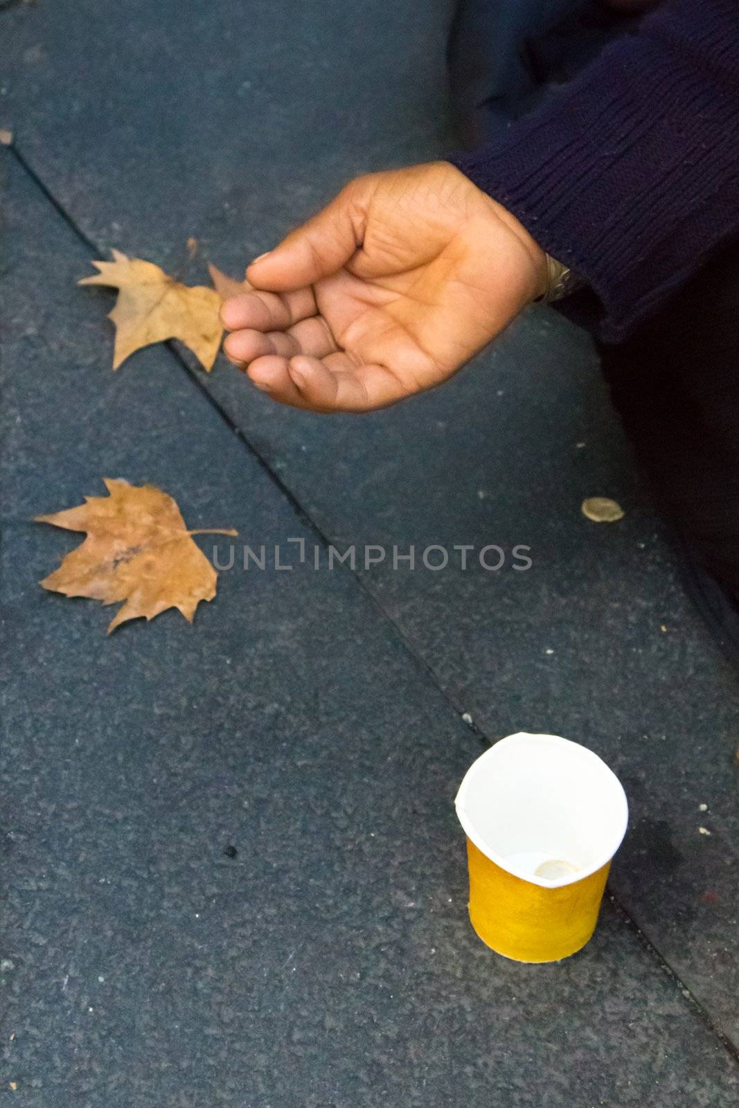A hand begging for money on a street in Madrid