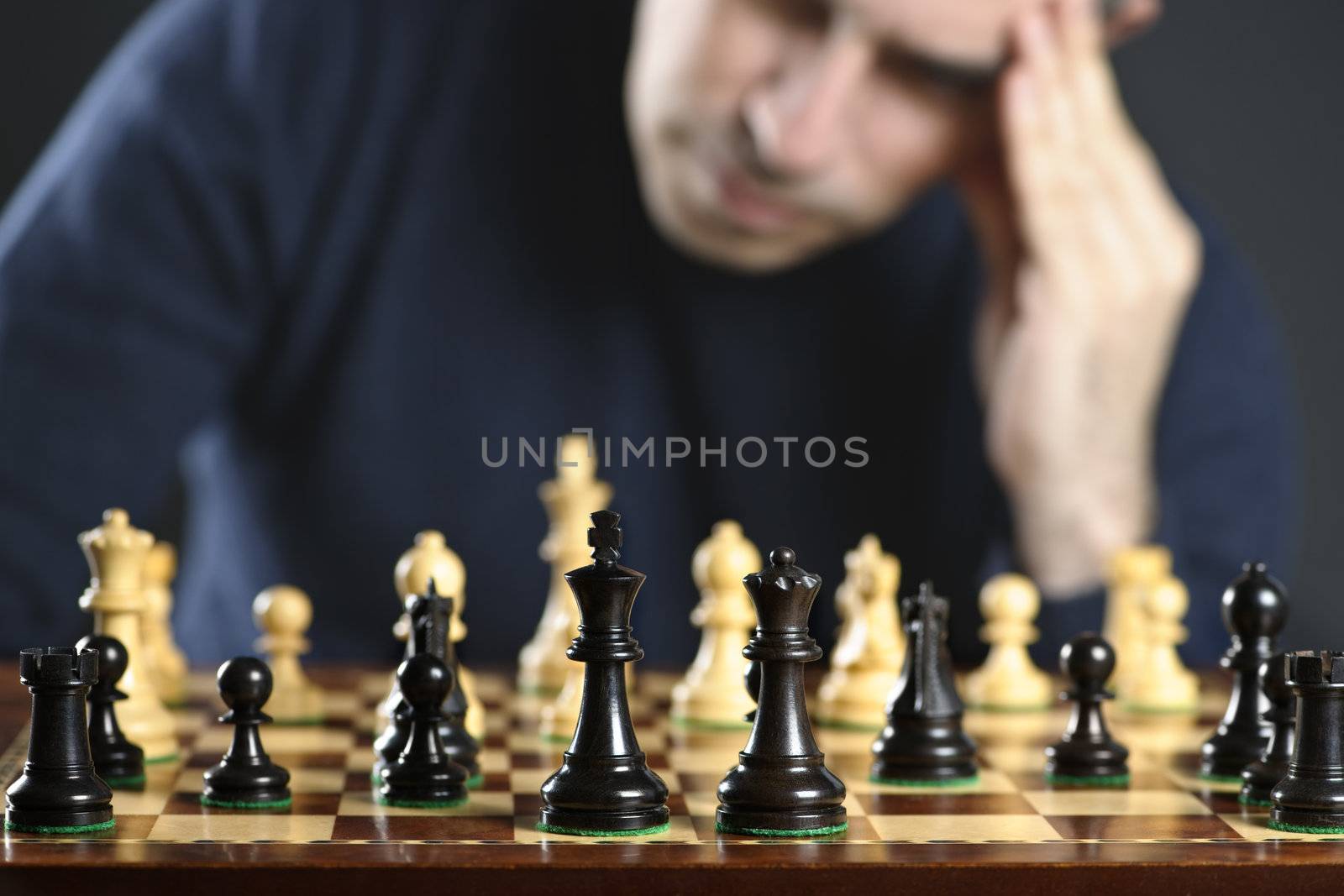 Chessboard with man thinking about chess strategy