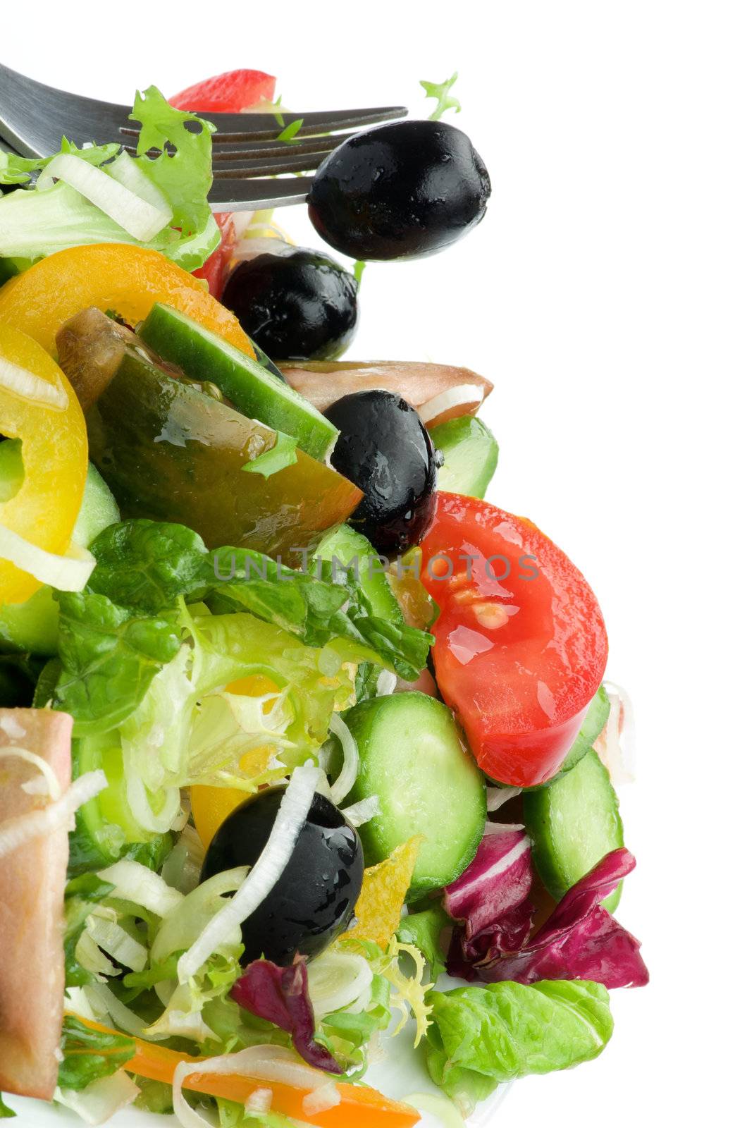 Vegetable Salad with Tomatoes, Yellow Bell Pepper, Leek, Cucumber, Lettuce, Olive Oil and Fork with Black Olive on White background