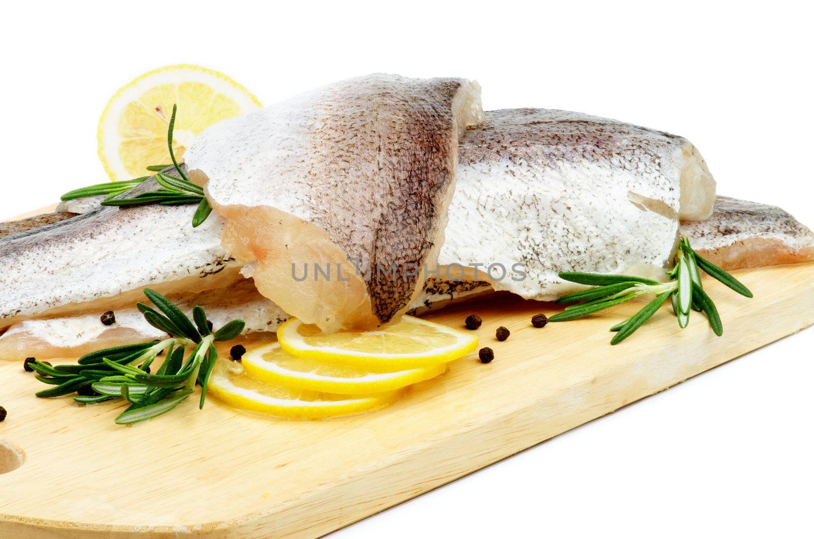 Raw Fish Hake Fillets with Lemon, Black Peppercorn and Rosemary on Cutting Board closeup on white background