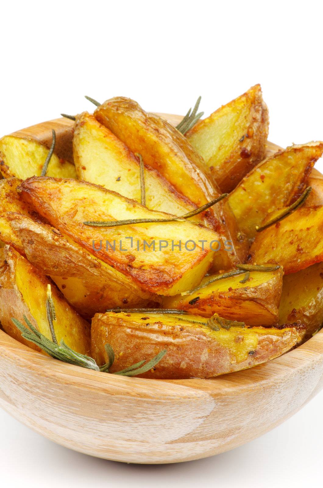 Roasted Potato Wedges with Rosemary and Herbs in Wooden Bowl closeup on white background