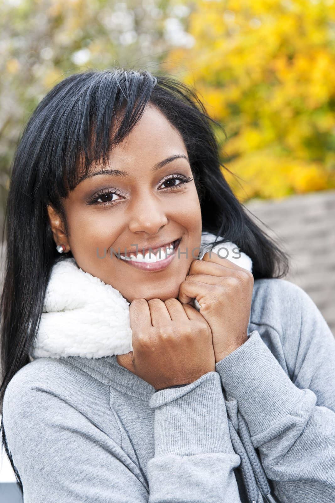 Portrait of happy smiling young black woman outside in the fall