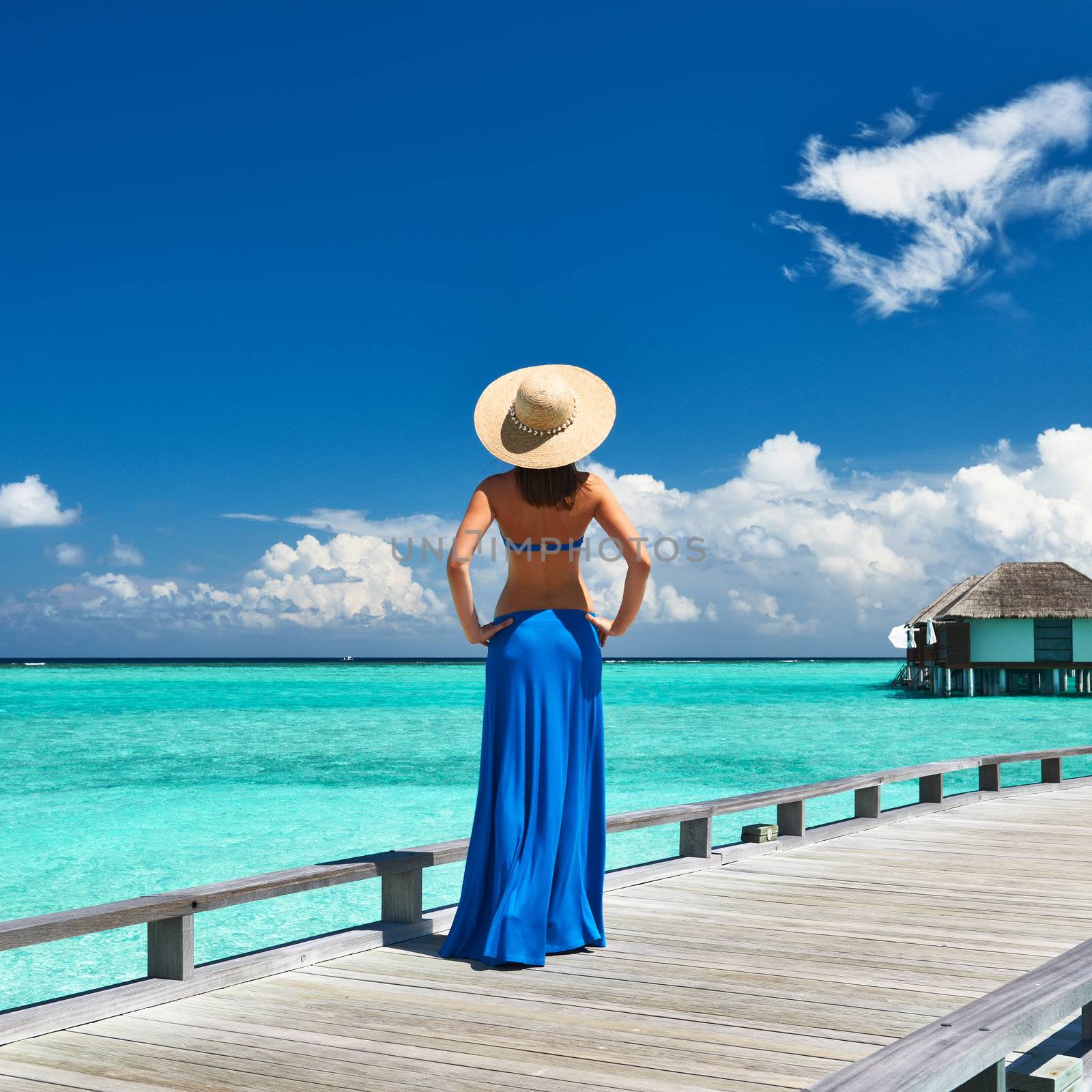 Woman on a tropical beach jetty at Maldives