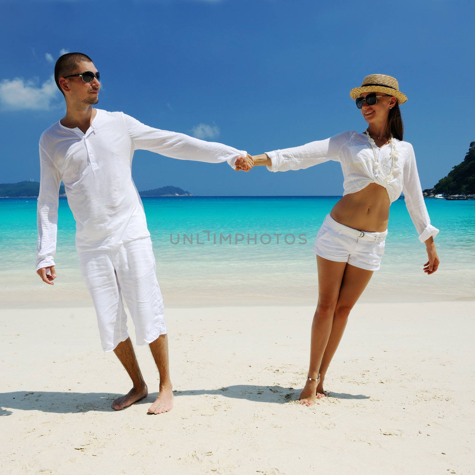 Couple in white on a beach by haveseen
