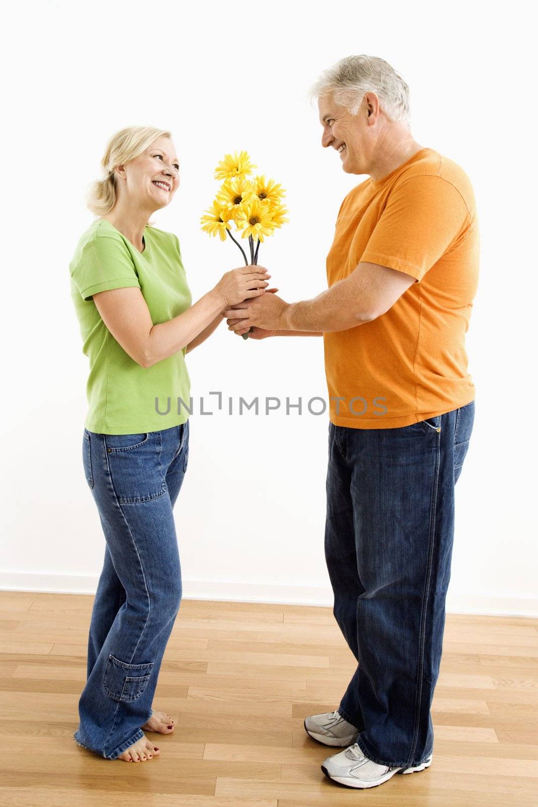Man giving woman bouquet. by iofoto