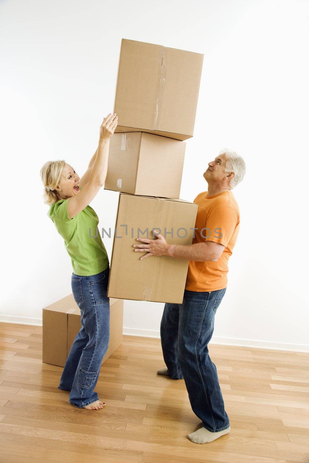 Woman stacking boxes. by iofoto