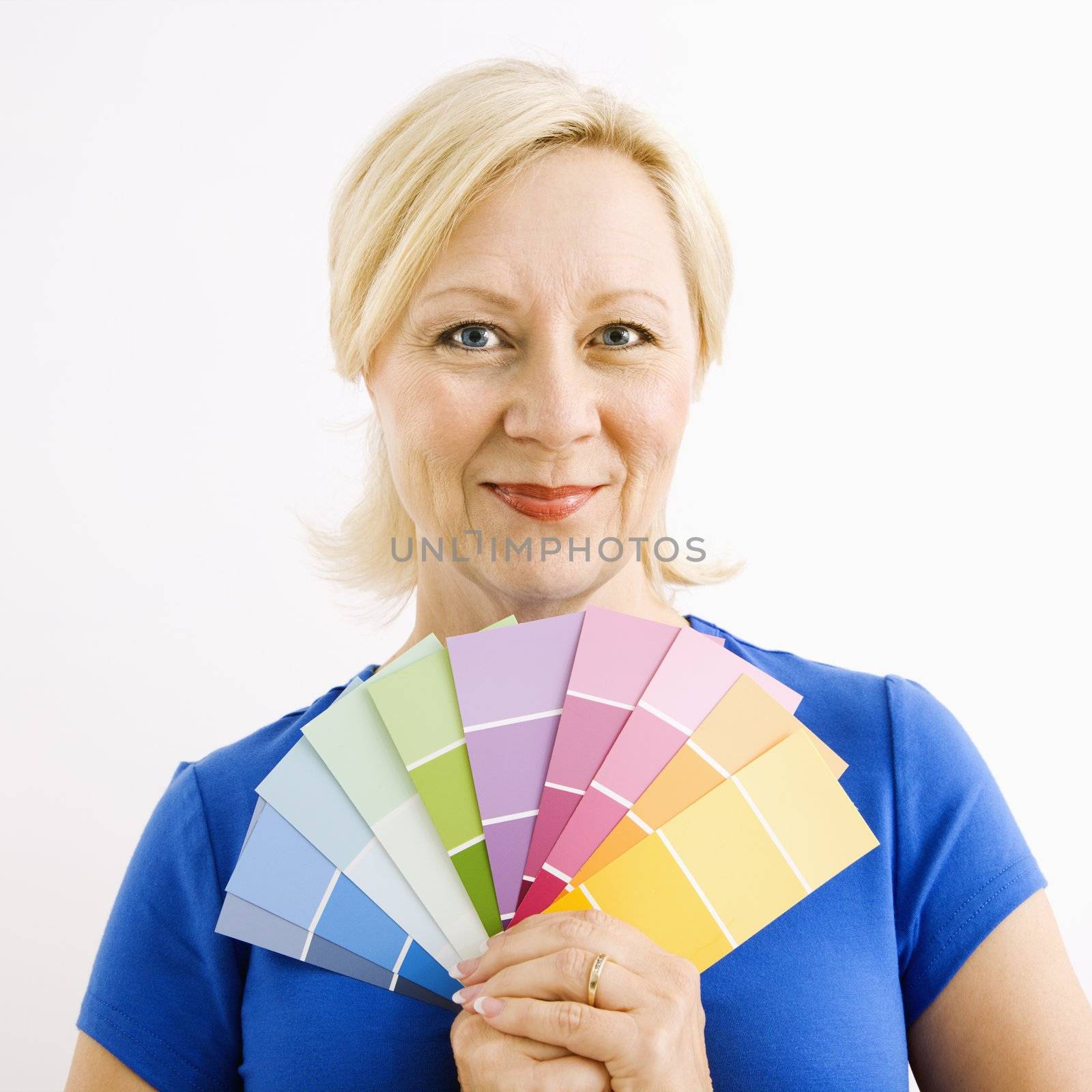 Portrait of smiling adult blonde woman holding paint swatches.