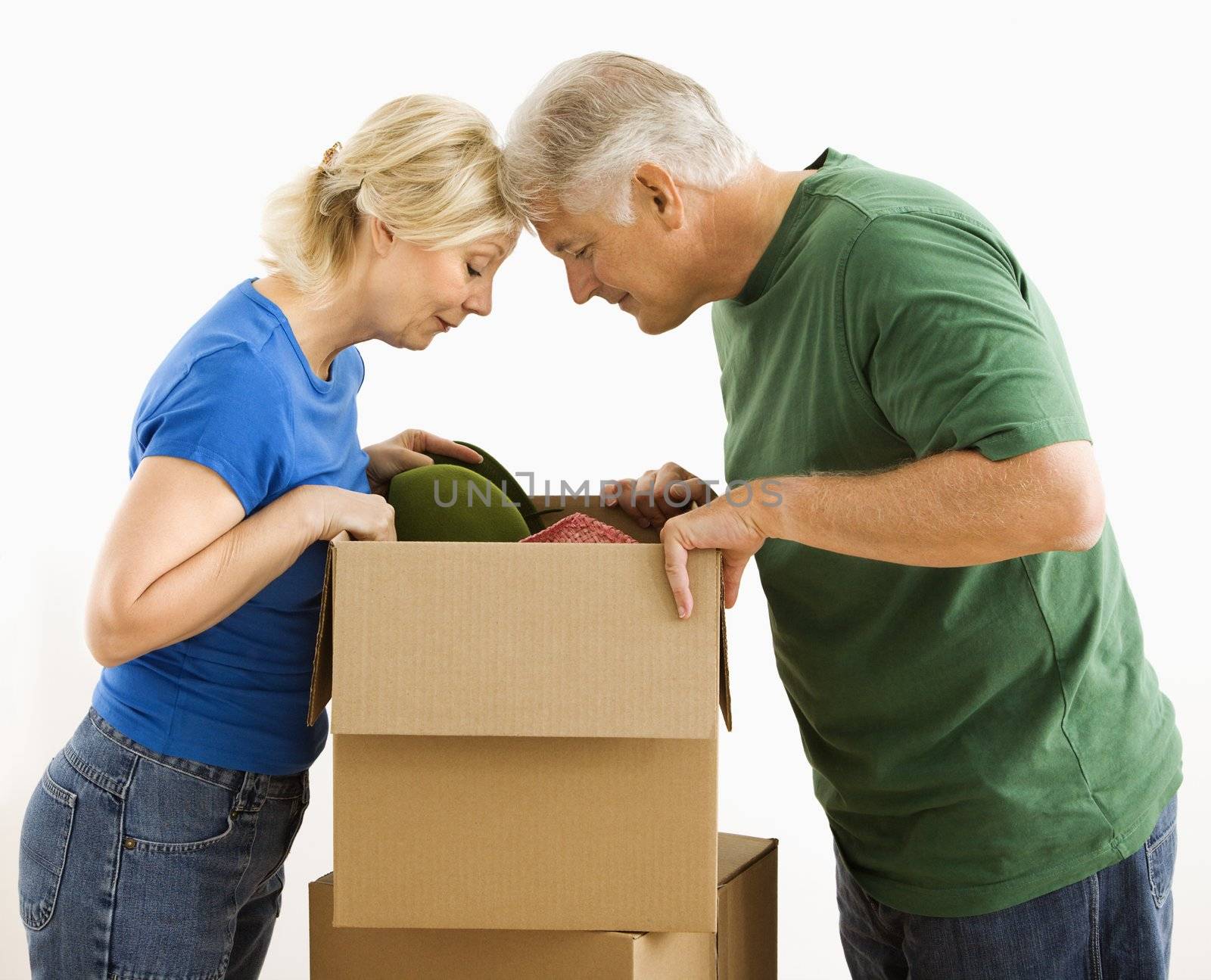 Middle-aged couple looking through cardboard box.