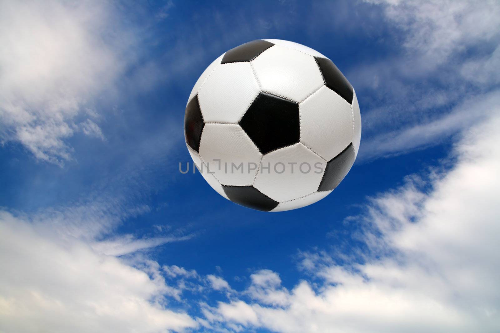 football soccer ball under blue sky with clouds
