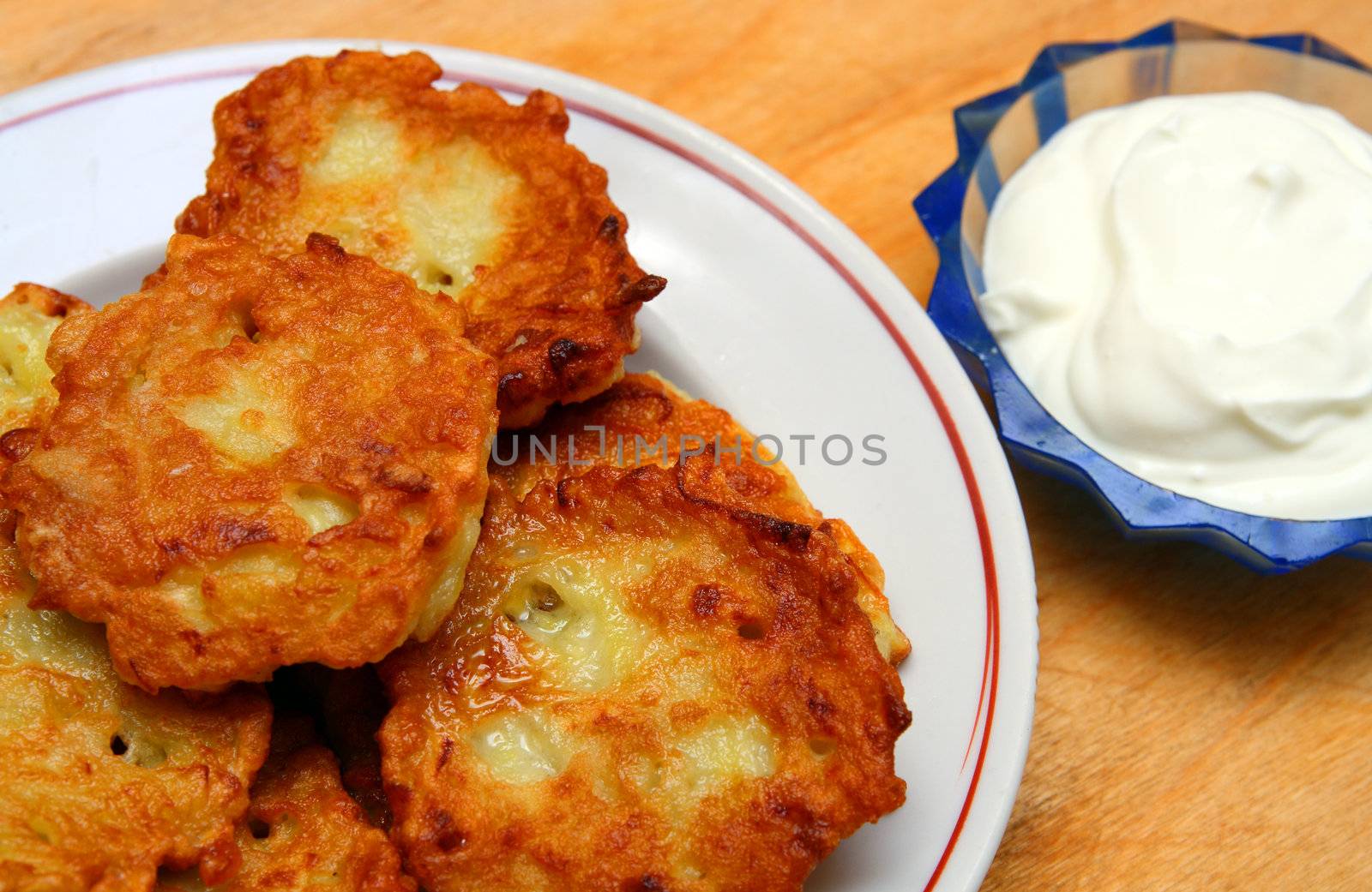 potato pancakes on plate with sour cream