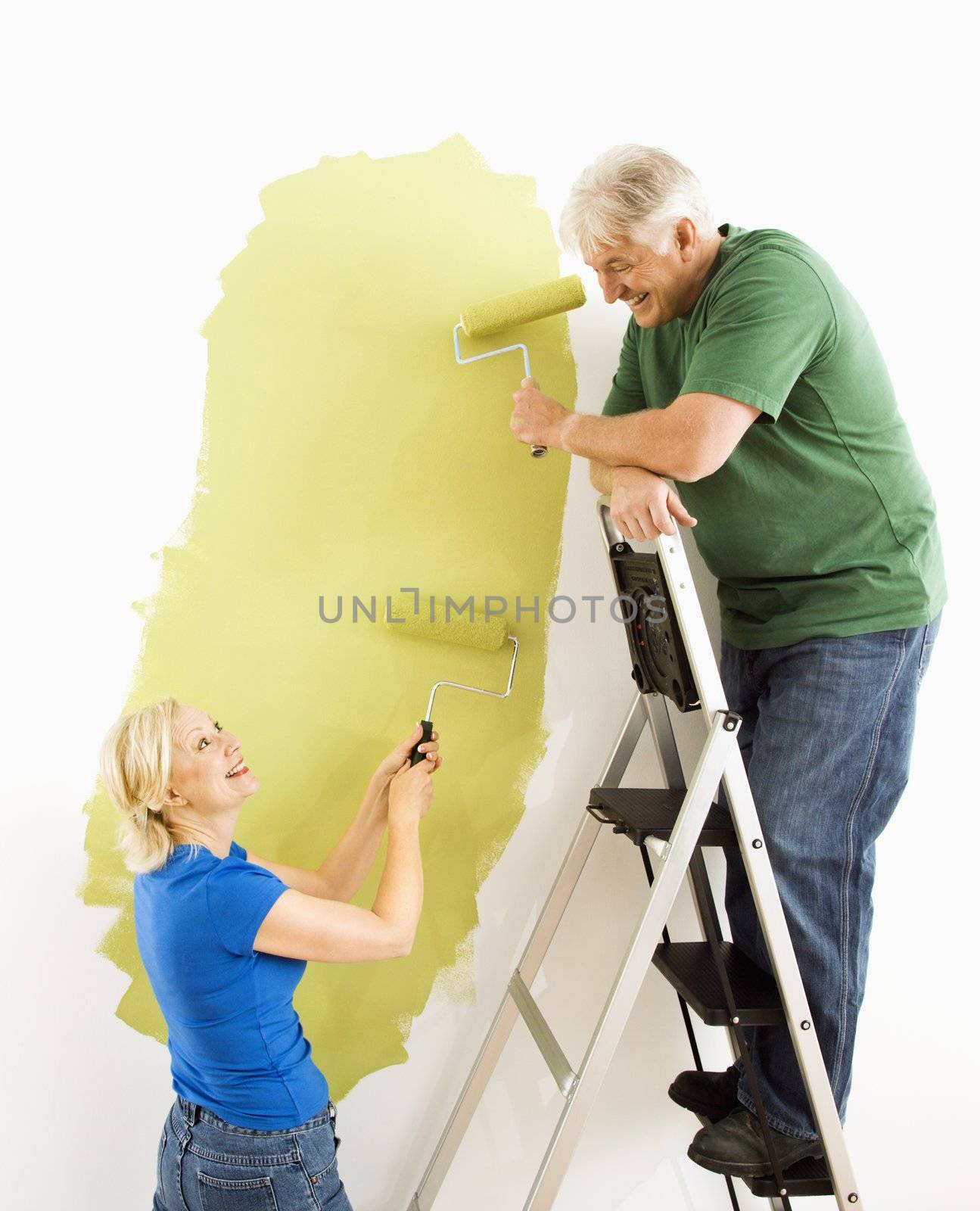 Couple painting wall. by iofoto