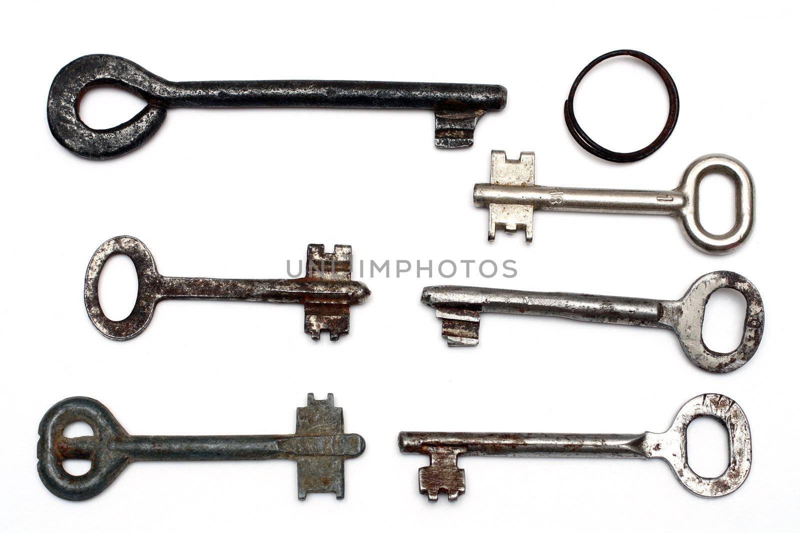 six old rusty keys and keyring isolated on white