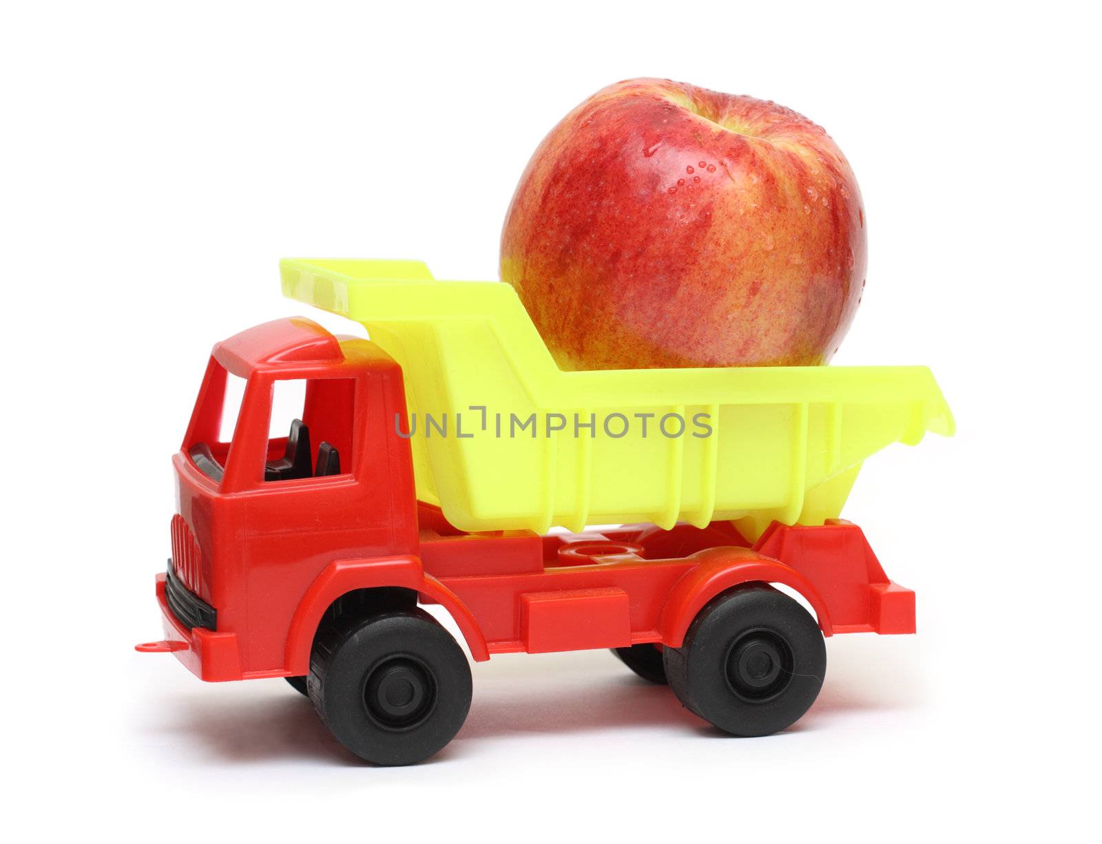 food transportation concept - toy lorry with apple isolated on white