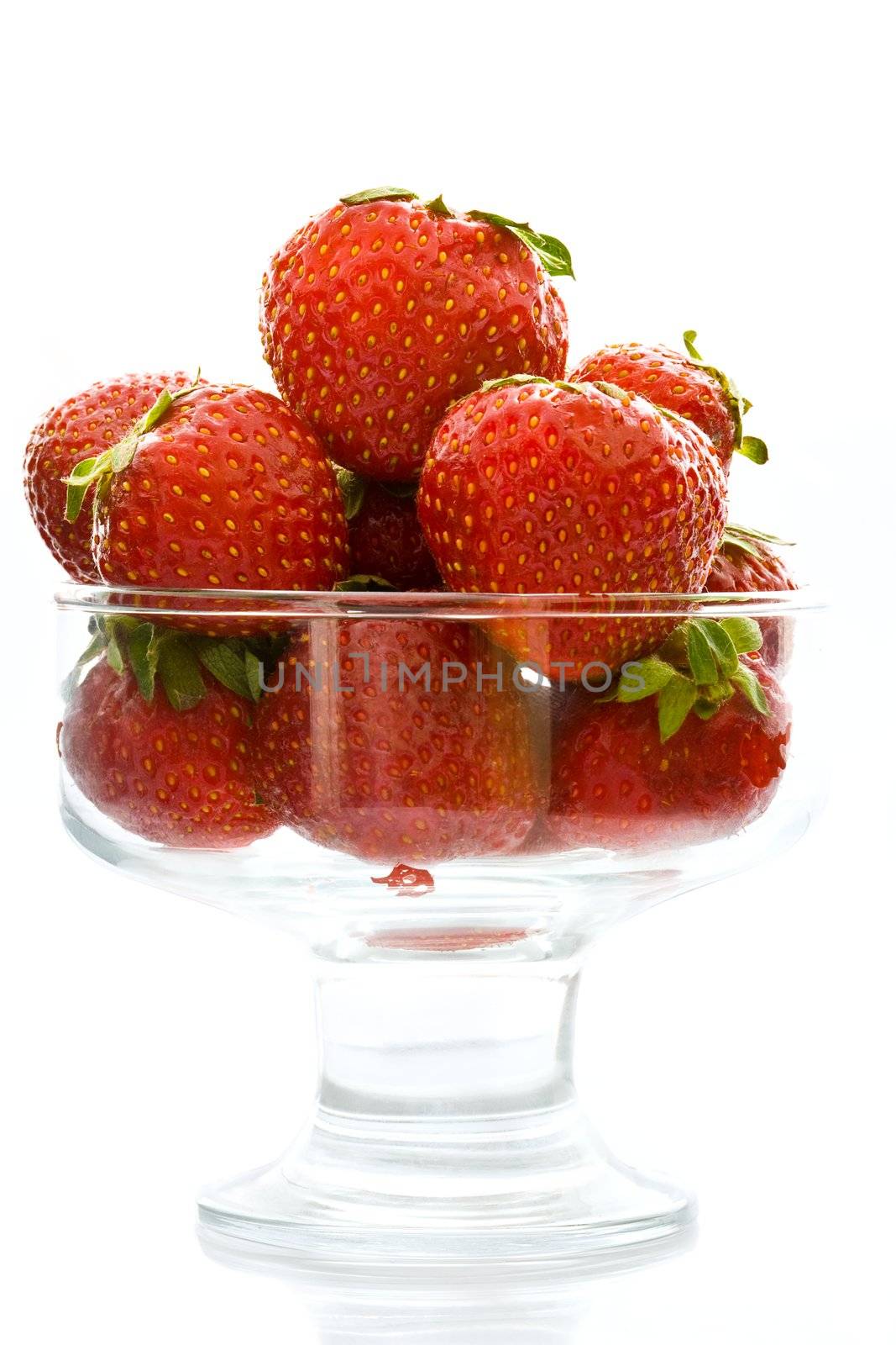 Ripe strawberry in a glass vase on a white background

