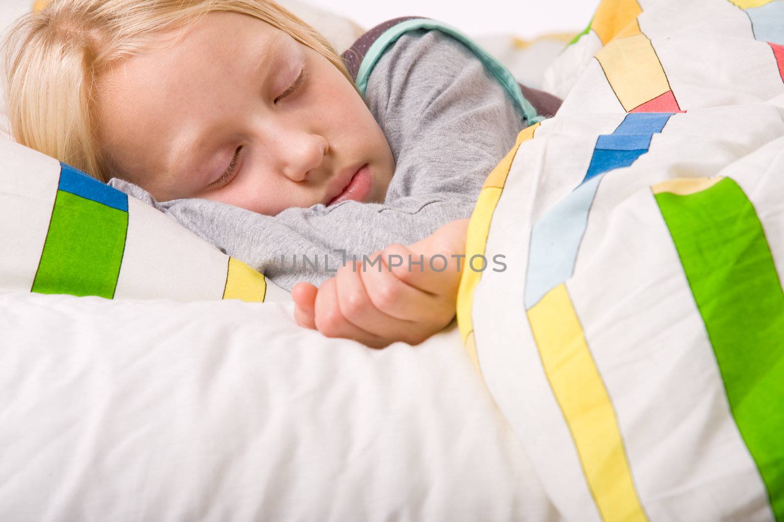 Sleeping young cute child in a colorful bed