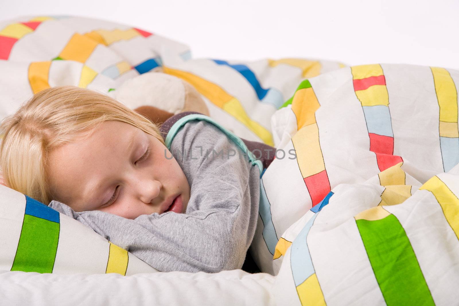 Sleeping young cute child in a colorful bed