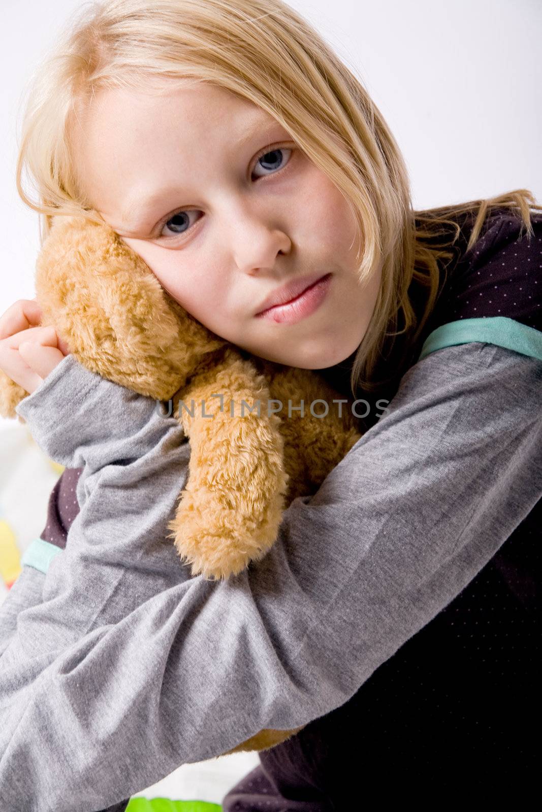 Happy blond girl hugging with her toy