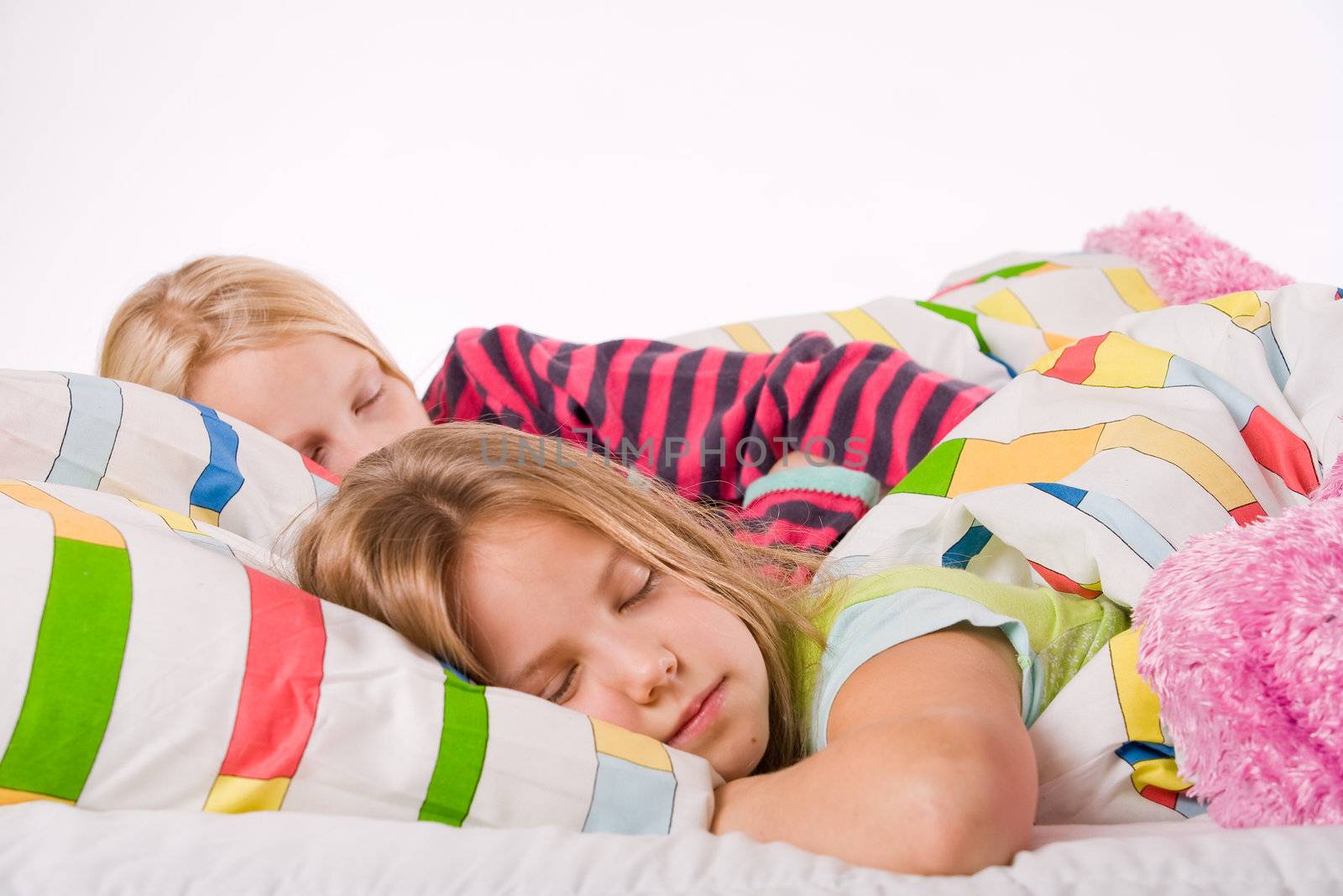 Two young children enjoying their colorful bed