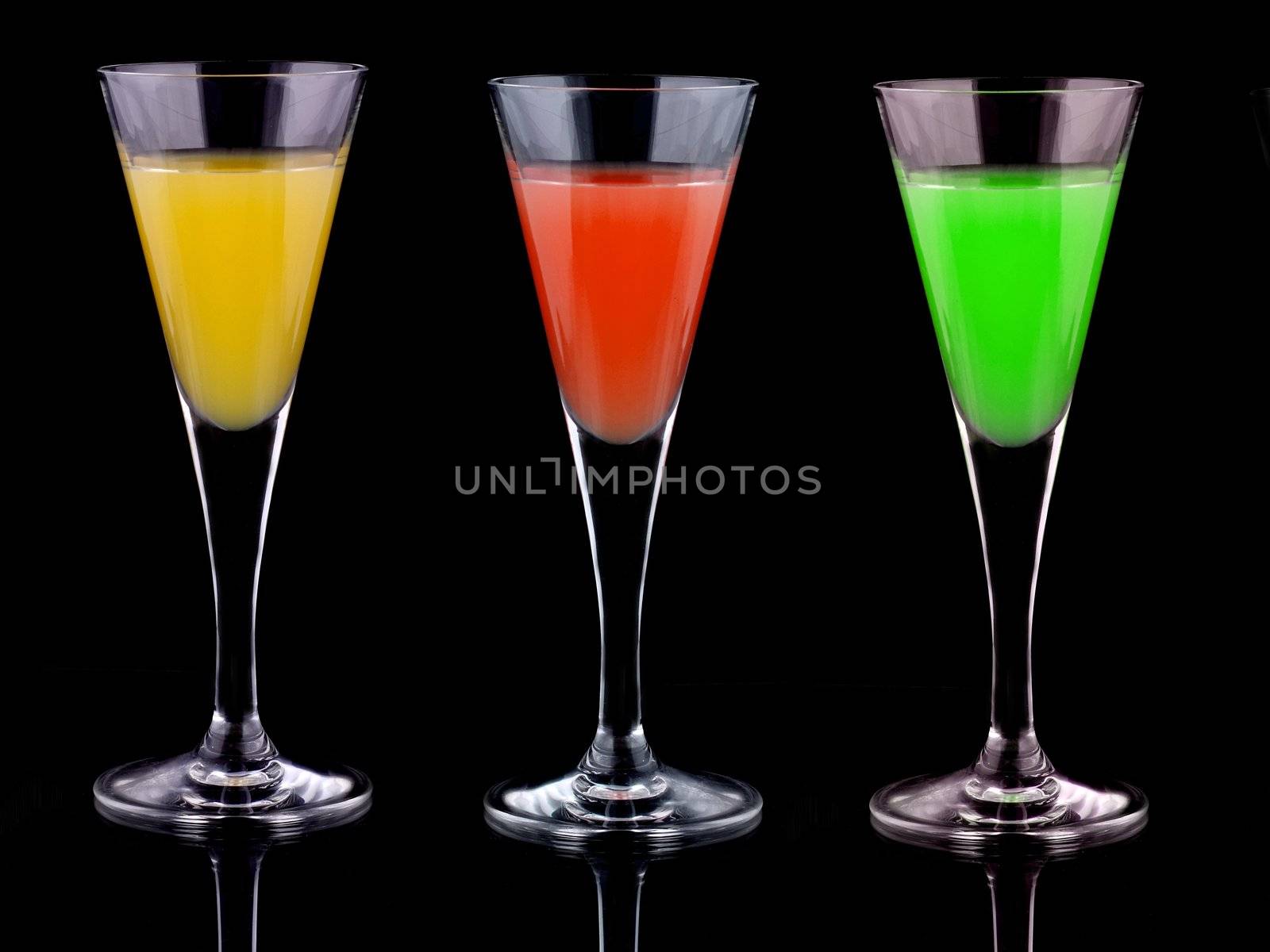 three glasses with liquor of diferent colors