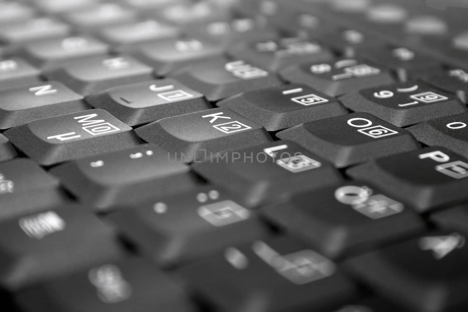 Detail view on gray laptop keys. Shallow depth of field. Focus on M, K, O.