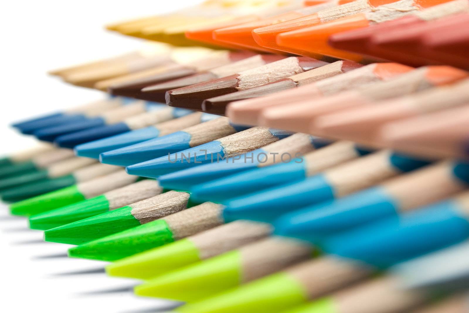 Stacked colored pencils on a white background. Shallow depth of field.