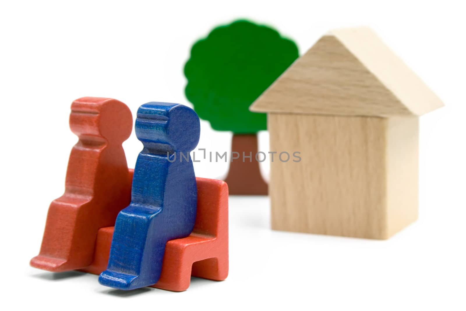 Couple sitting in front of their home. Playthings isolated on a white background.