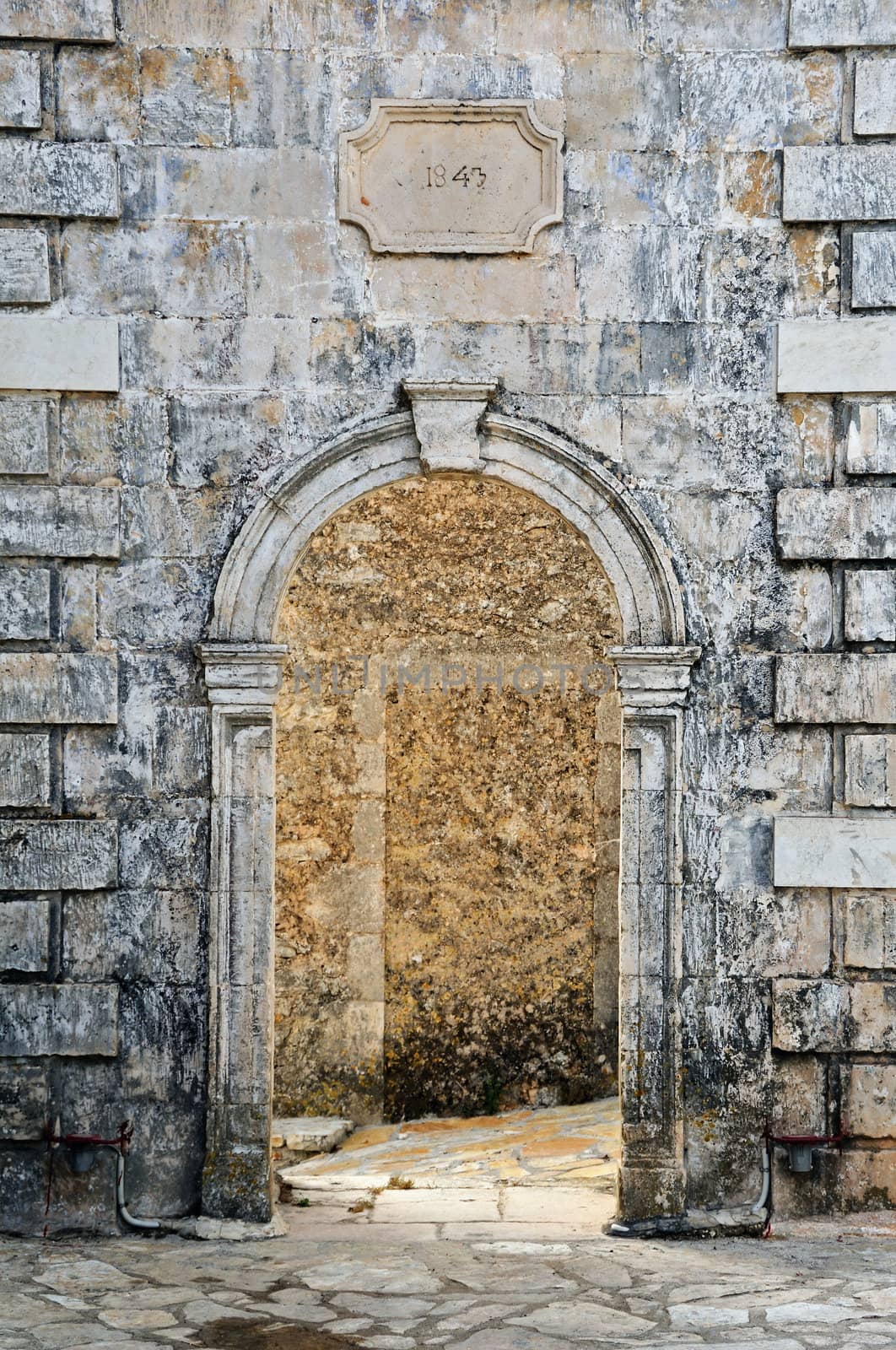 Arched gate weathered venetian belfry detail at village Louha in Zakynthos, Greece.