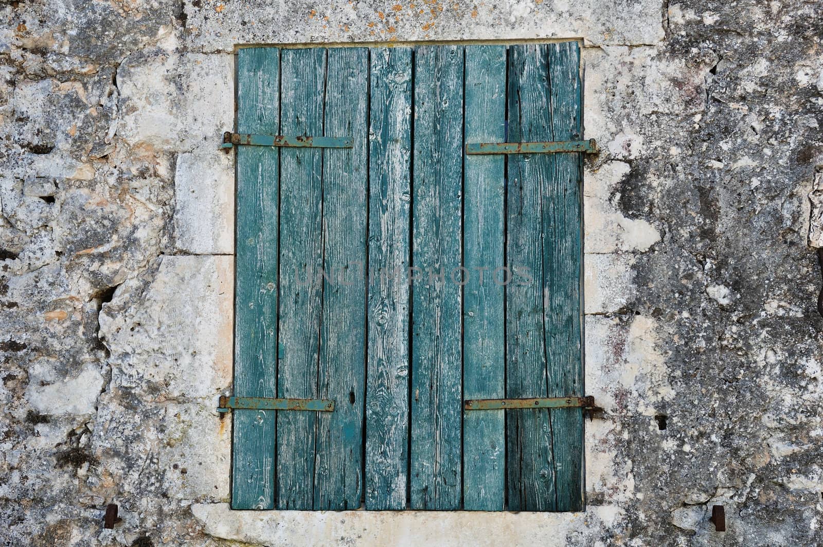 Stone wall and blue window shutter. Traditional house in Zakynthos, Greece.