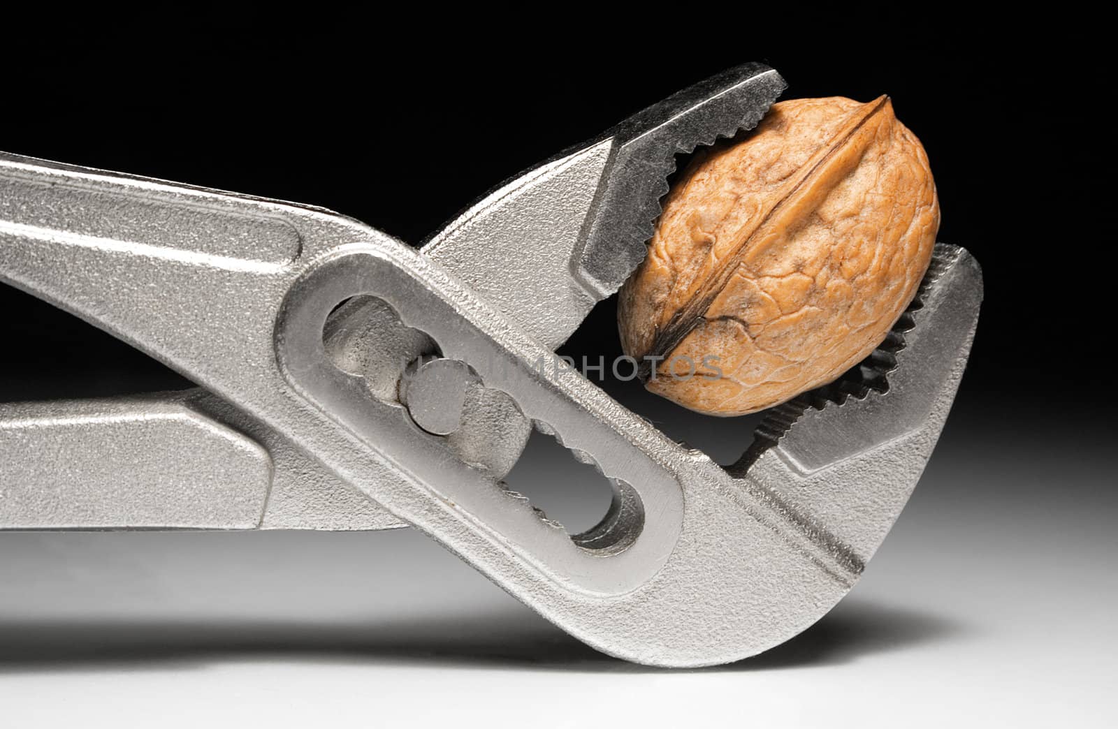 Metal pliers cracking a walnut.