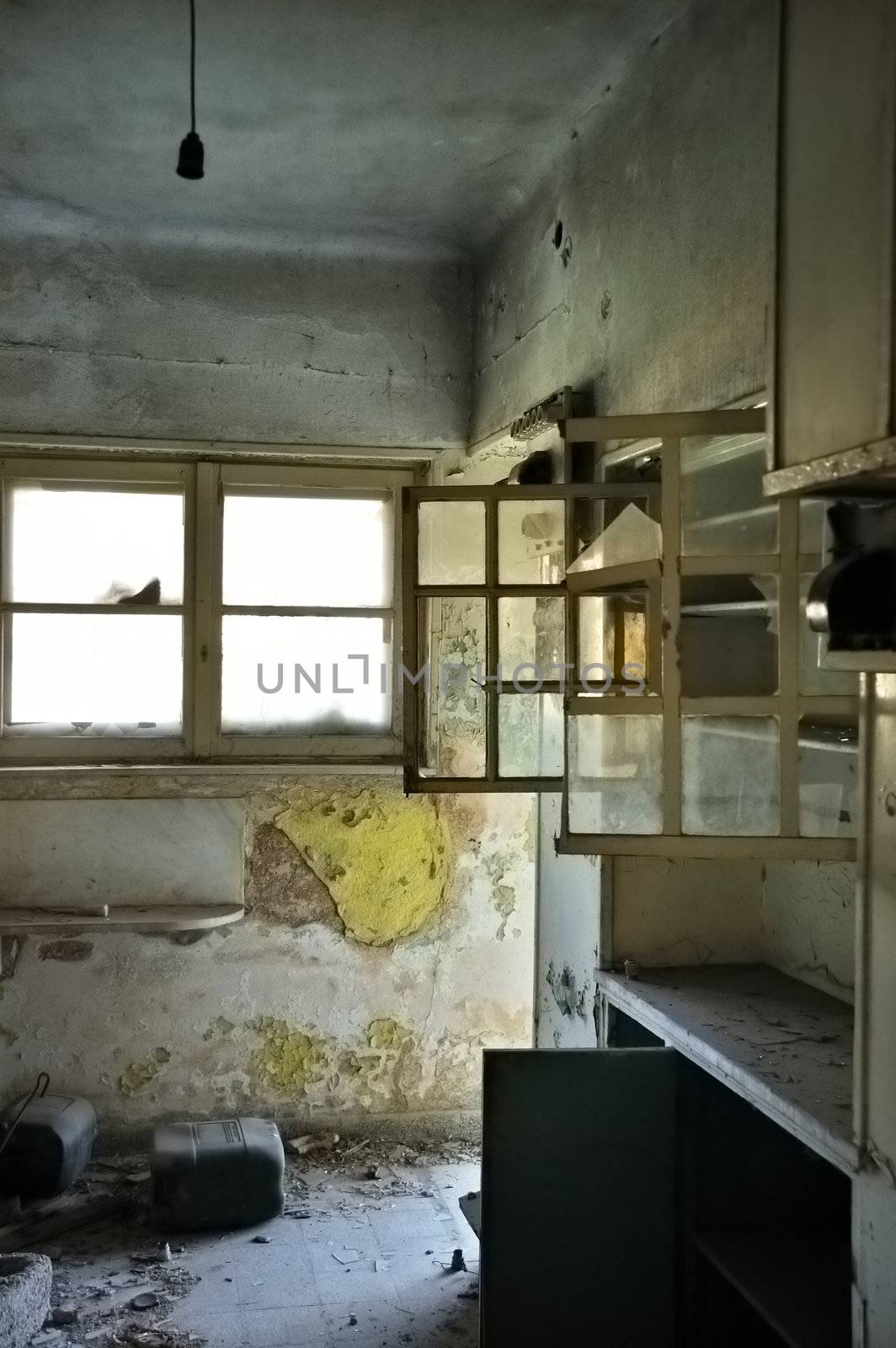 Dusty cabinets and textured wall in empty room. Abandoned house interior.
