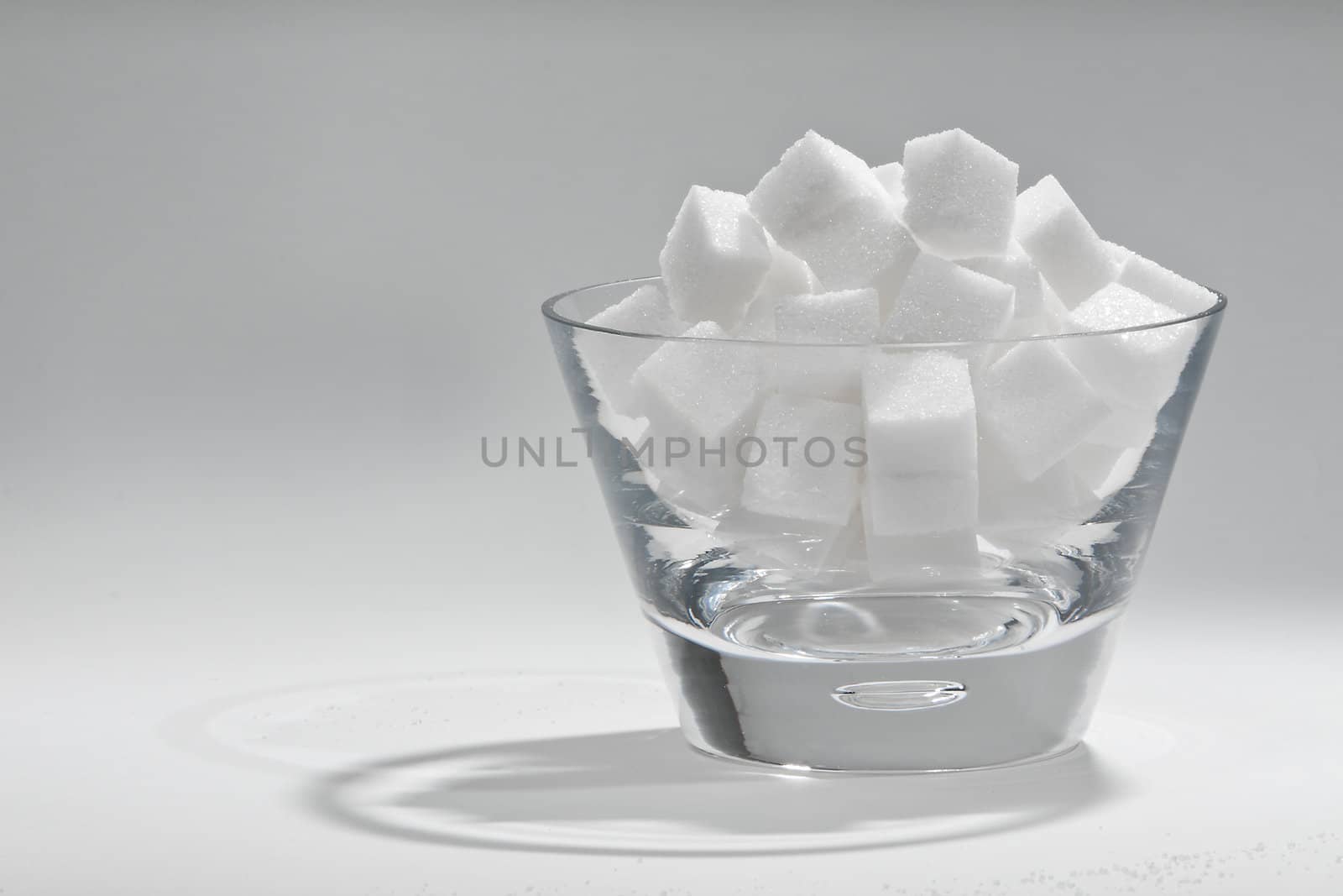 Glass bowl filled with sugar cubes.