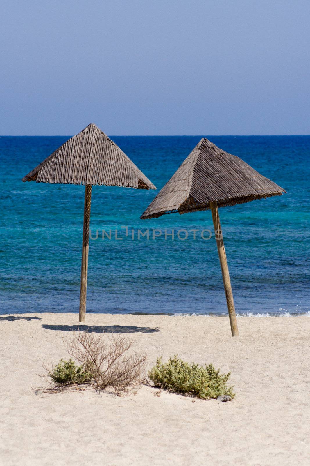 Two lonely sun umbrellas at the beach.