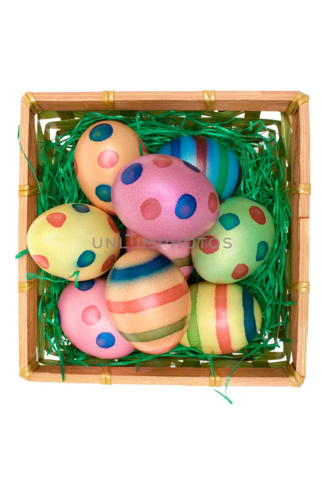 Easter eggs in a wooden basket. Isolated on a white background.
