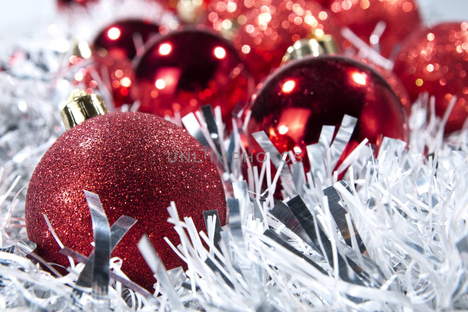 Red Xmas baubles on white. Shallow depth of field.