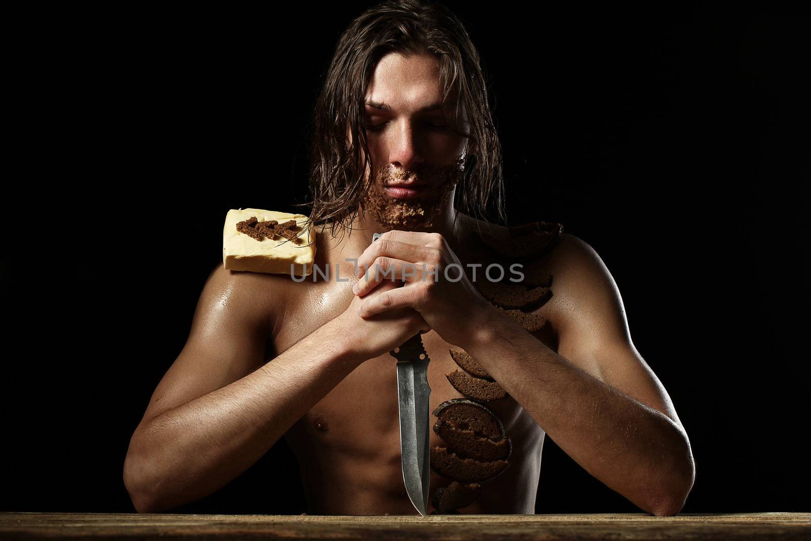 Art photo of young man with beard of bread isolated over black background