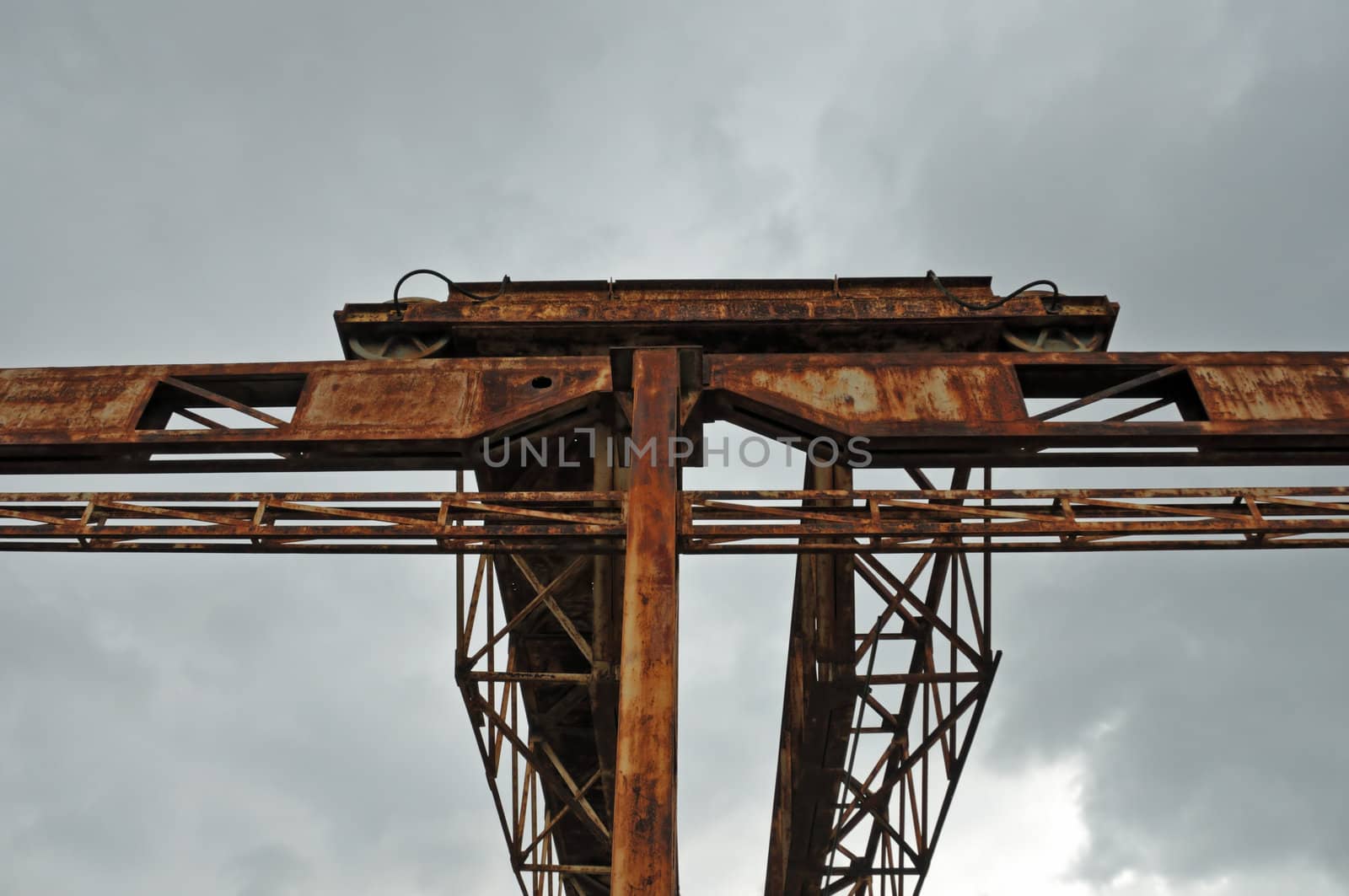 Rusty industrial gantry at abandoned marble processing factory.