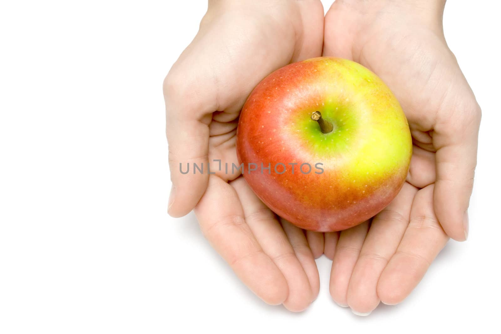 Female hands holding a colorful apple. Isolated on a white background.