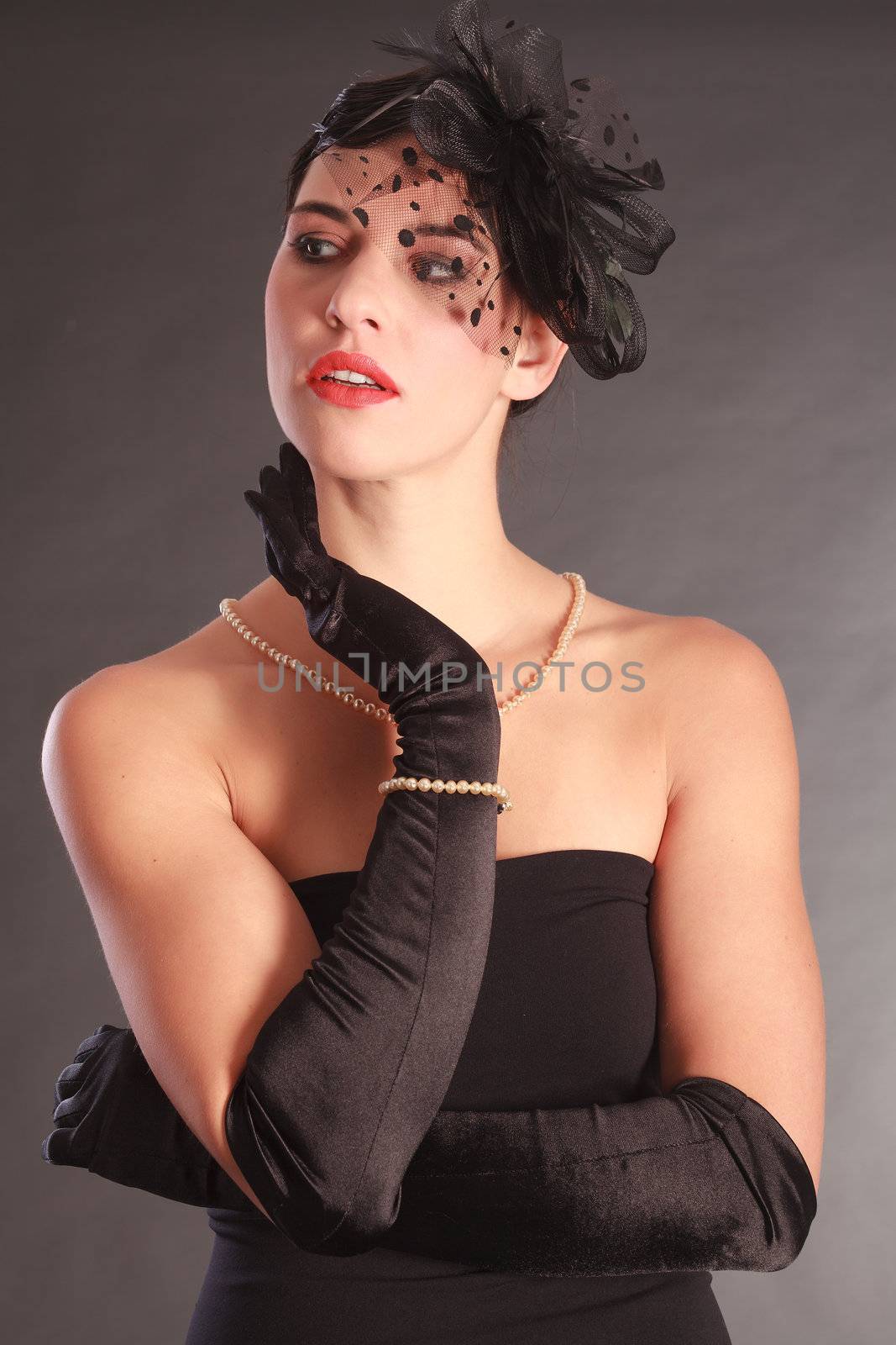 Beautiful woman with hair bow, evening dress and black gloves