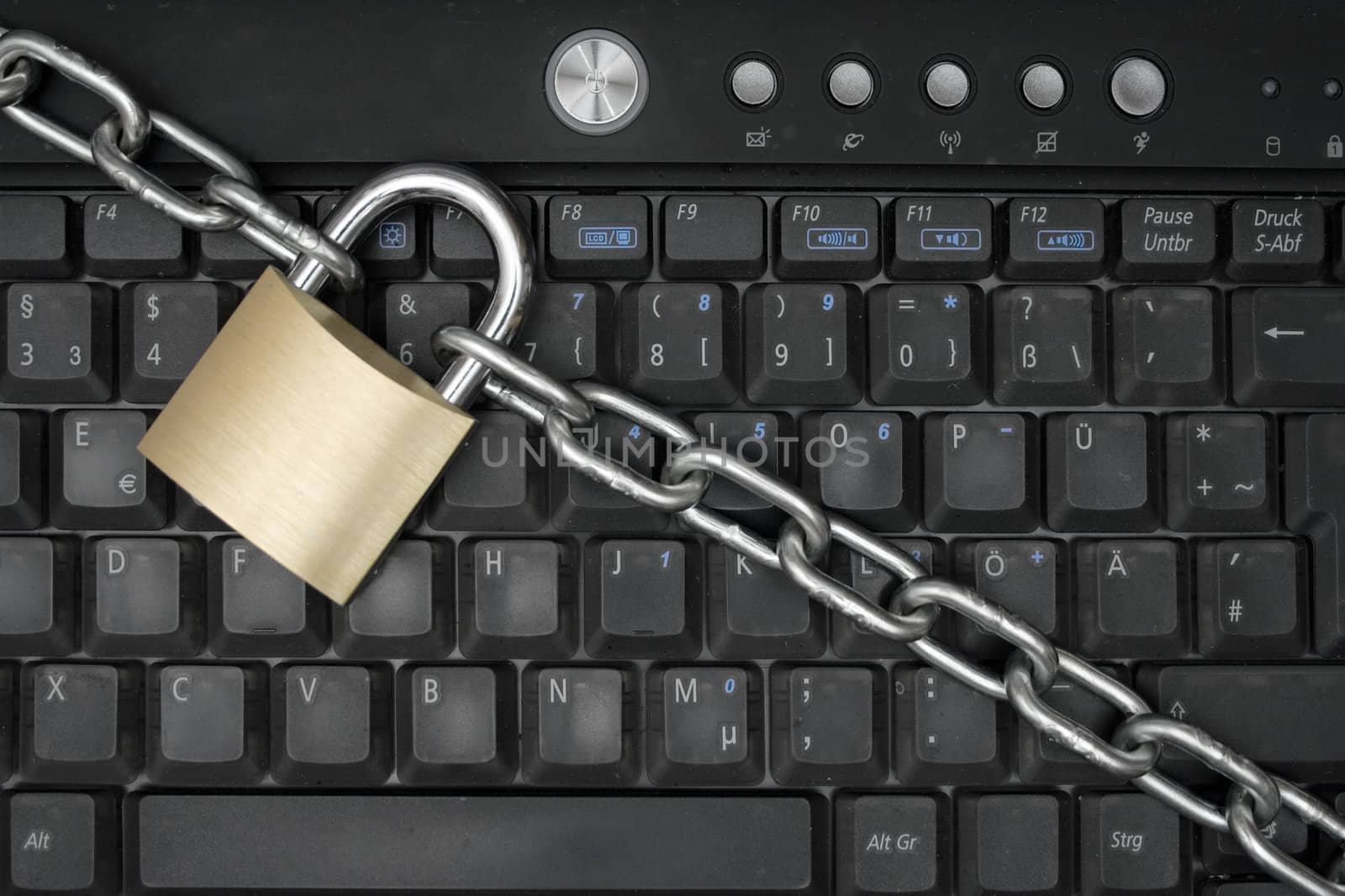 Padlock and chain locking a laptop keyboard.