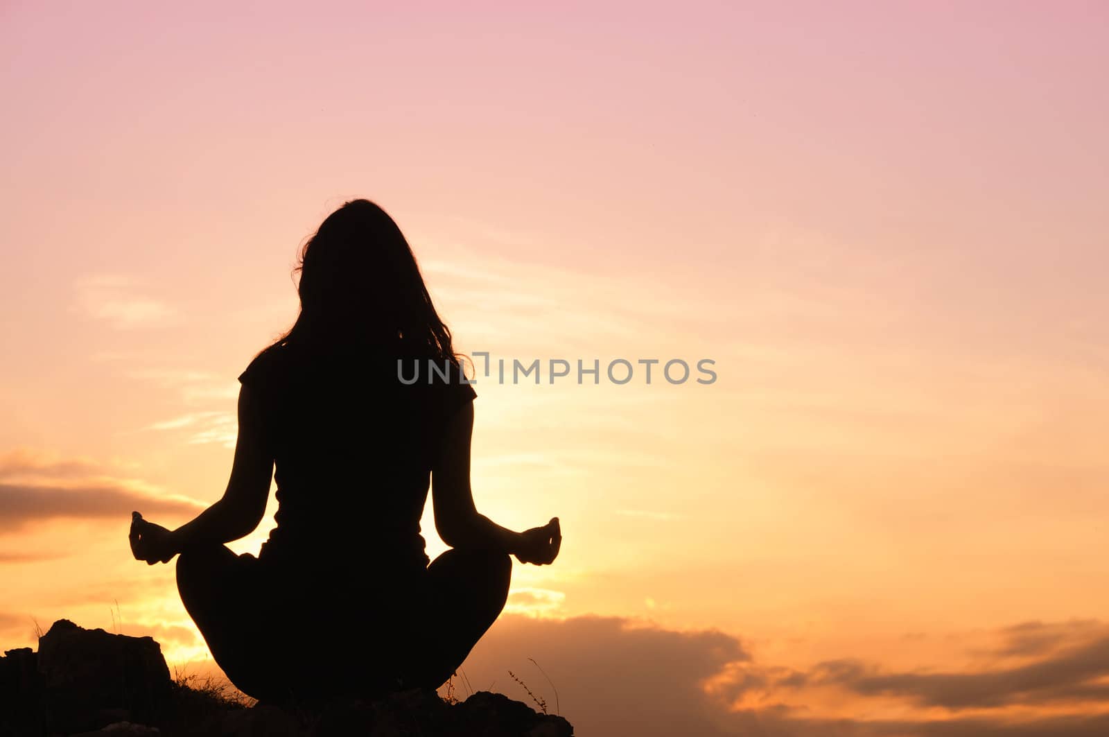 Silhouette of unrecognizable person meditating