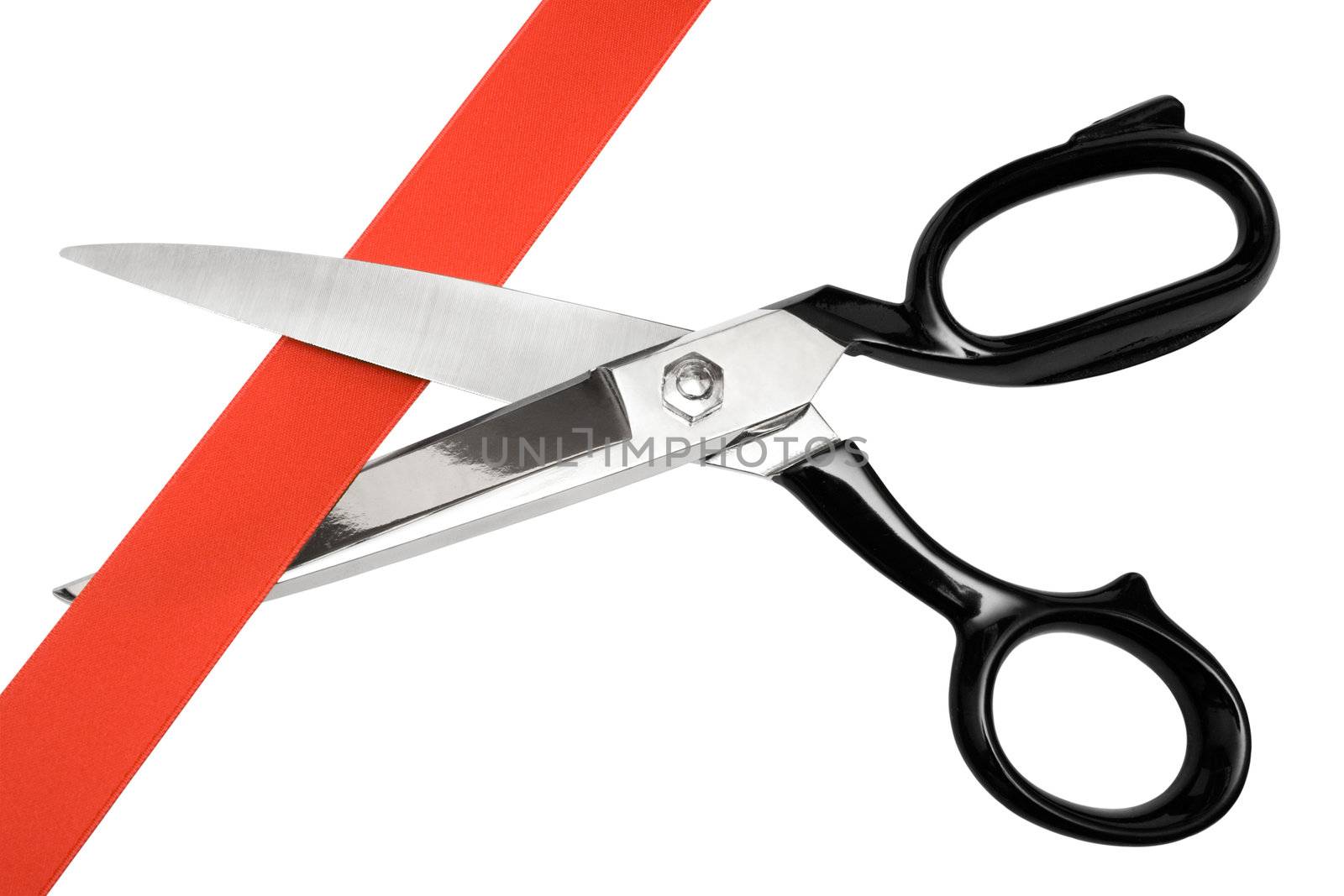 Pair of scissors cutting red ribbon. Isolated on a white background.
